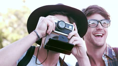 hipster friends taking pictures with an old camera