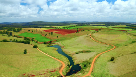 aerial view of lush green fields and river in atherton tablelands, queensland, australia - drone shot