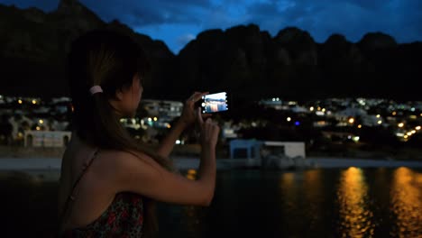 woman taking picture on on promenade at beach 4k