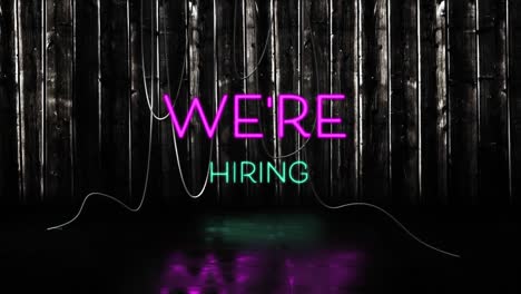 animation of we're hiring text in pink and blue neon letters on black background