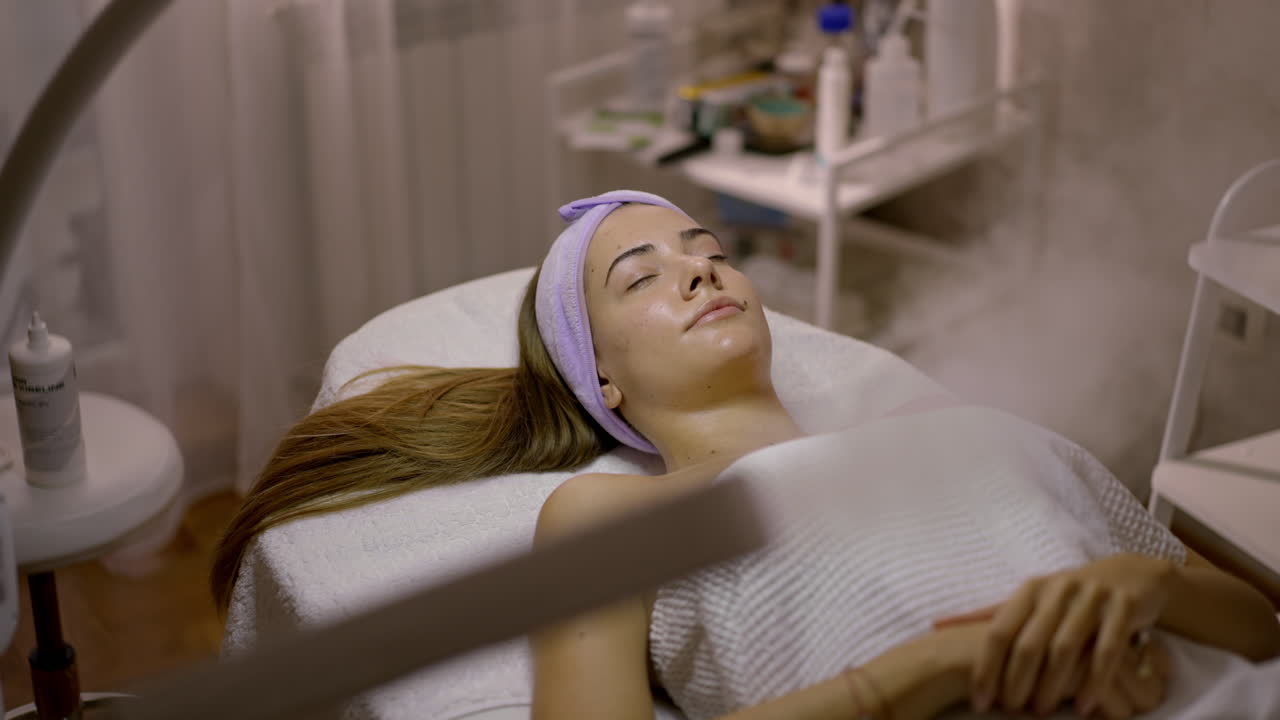 Woman receiving a facial steam treatment at a beauty salon