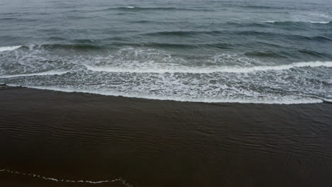 View-from-the-beach-of-small-Pacific-Ocean-waves-washing-ashore-on-Oregon-Coast