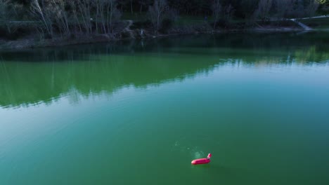 el oxígeno sube a la superficie en un lago verde, alrededor de una boya roja.
