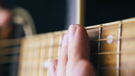 experienced guitarist prepares to play acoustic guitar