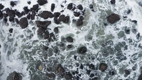 Vista-Aérea-De-Las-Olas-Del-Océano-Rompiendo-Contra-Las-Rocas-A-Lo-Largo-De-La-Costa,-La-Costa-De-Oregon-Del-Pulgar-De-Dios,-De-Arriba-Hacia-Abajo-Ascendente