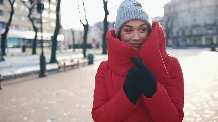 Donna con cappotto rosso in una strada invernale