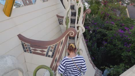 Woman-descends-a-staircase-while-exploring-the-unique-and-whimsical-Crazy-House-in-Da-Lat,-Vietnam