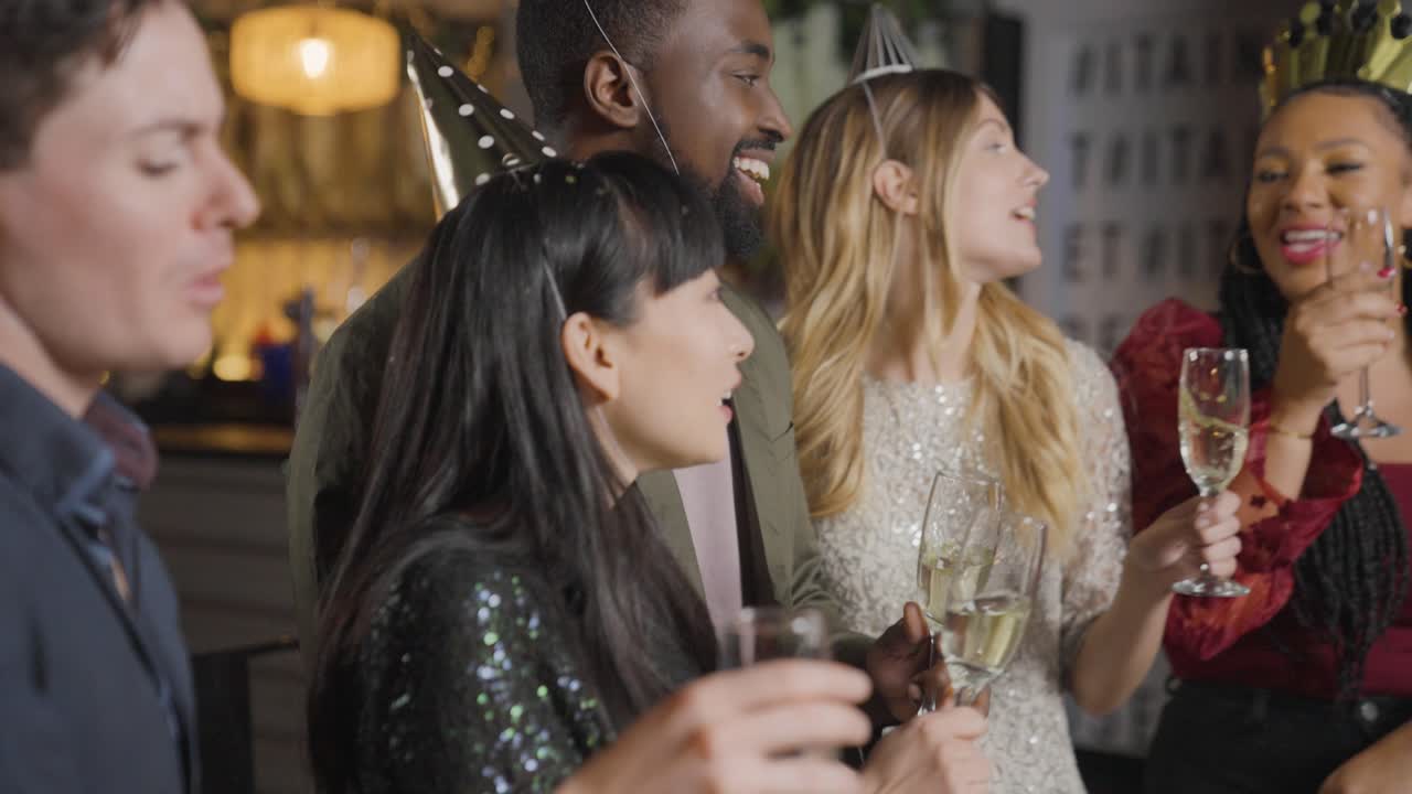 바에서 춤을 추고 새해 전야를 축하하는 친구에게 접근하는 추적 샷