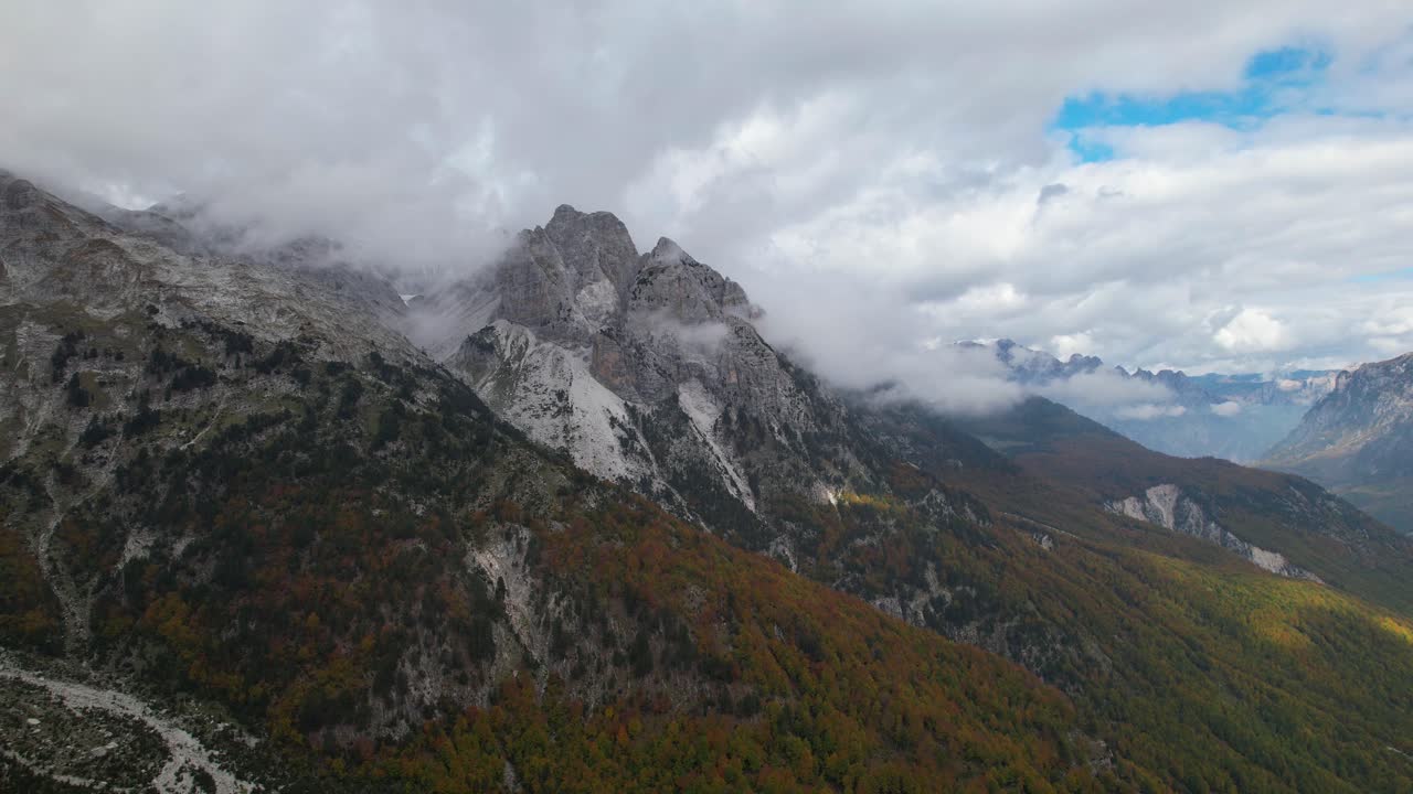grandes montañas en los alpes de albania cubiertas de niebla en la temporada de otoño con bosques coloridos
