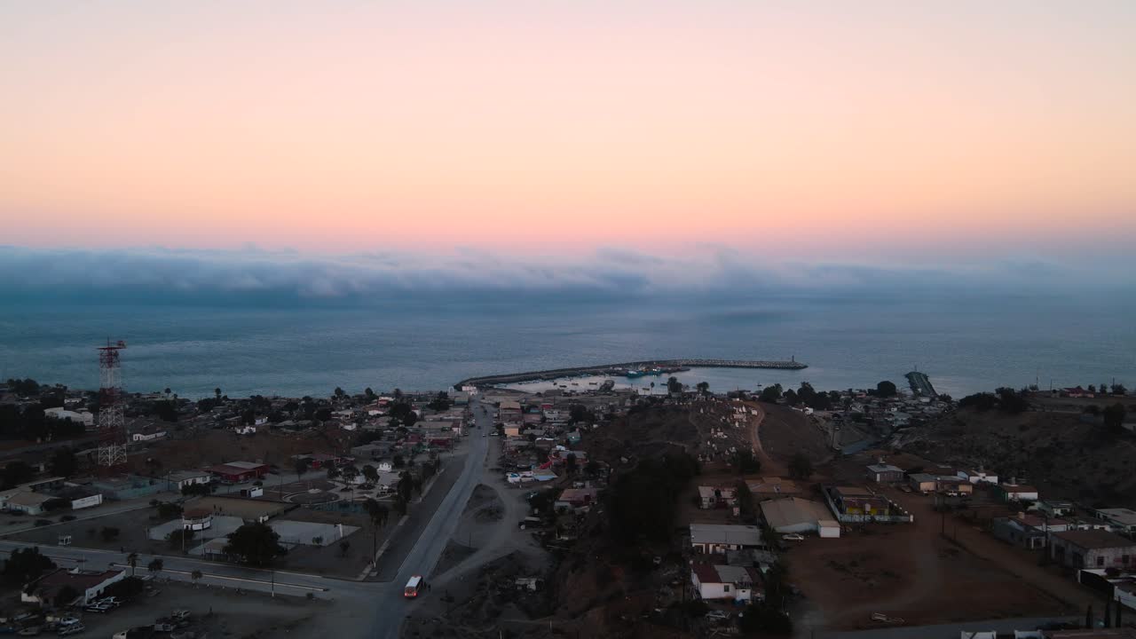 Aerial dolly over Cedros Island at dusk with rugged landscapes and a glowing horizon over the coastline