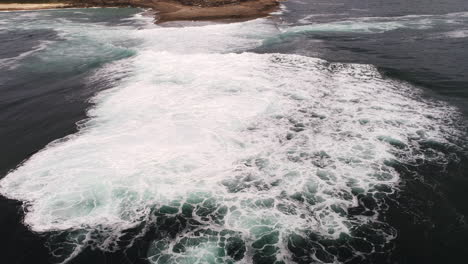 aerial top view of whitewater breaking wave in deep sea, powerful ocean energy