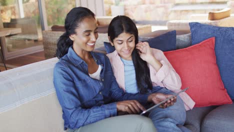 Video-of-happy-diverse-female-friends-using-tablet-on-sofa