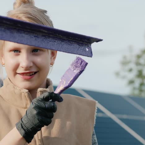 a child paints poles at a home solar power plant 2