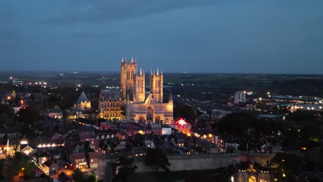 Aerial-drone-video-captures-the-renowned-Lincoln-Cathedral-in-Lincolnshire,-UK,-at-dusk,-showcasing-its-majestic-Gothic-architecture-with-illumination