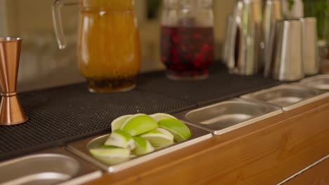 rustic bar setup with lime slices, copper jiggers, and pitchers of drinks, ready for cocktails