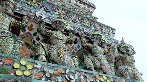 ornate statues adorning wat arun temple in bangkok, thailand