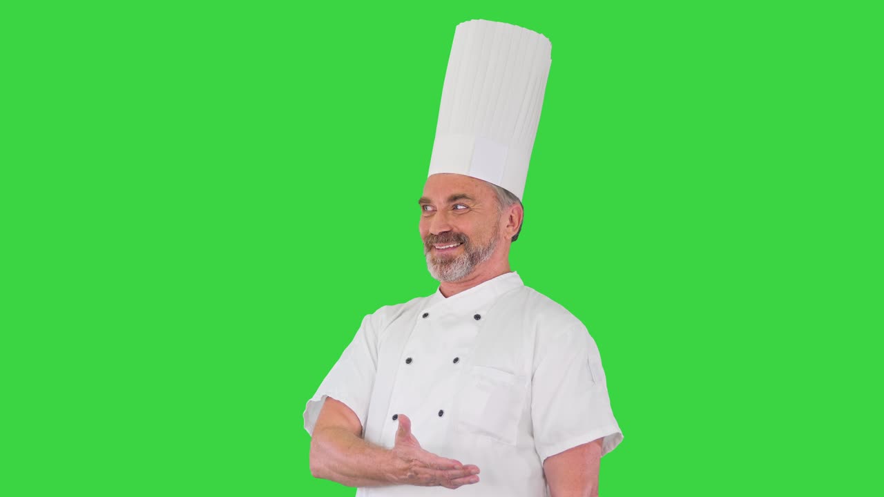 Chef anziano che accoglie gli ospiti del suo ristorante su Green Screen, Chroma Key.