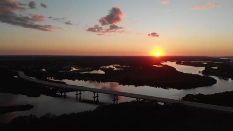 Vista-Aérea-Cayendo-Desde-Un-Puente,-Mostrando-Una-Hermosa-Puesta-De-Sol-Sobre-El-Hermoso-Río-Manatí-En-Bradenton,-Florida