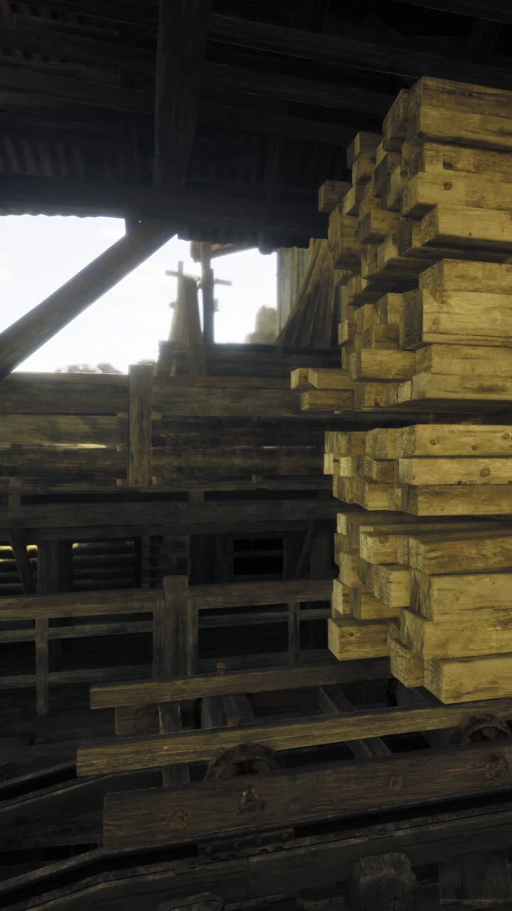 Travi di legno impilate all'interno di un edificio con struttura in legno e binari.