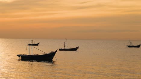 los barcos flotan suavemente en las aguas tranquilas del atardecer.