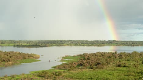 Amazon-River-near-Iquitos,-Peru-with-rainbow-and-boat-passing-by---Timemlapse-4k,-24fps