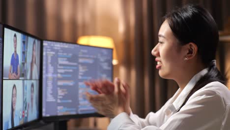 close up of asian woman programmer waving hand having a meeting on desktop computer while creating software engineer developing app, program, video game at home. terminal with coding language