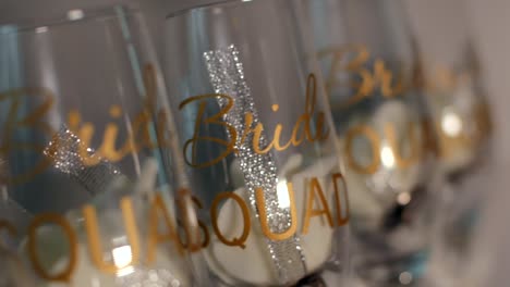 detailed handheld close-up of "bride squad" glasses featuring gold lettering and decorative elements, perfect for bridal celebrations.