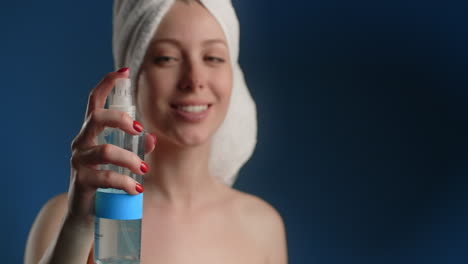 woman applying facial mist after shower