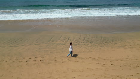 tourist walking on the shore of cofete beach in fuerteventura, canary islands, spain