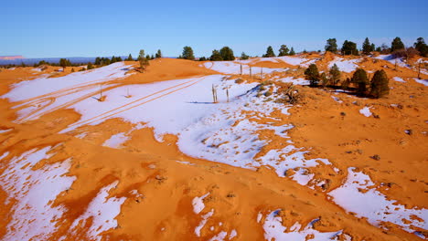 The drone sweeps across the pink sand dunes, emphasizing their bold colors and striking features.