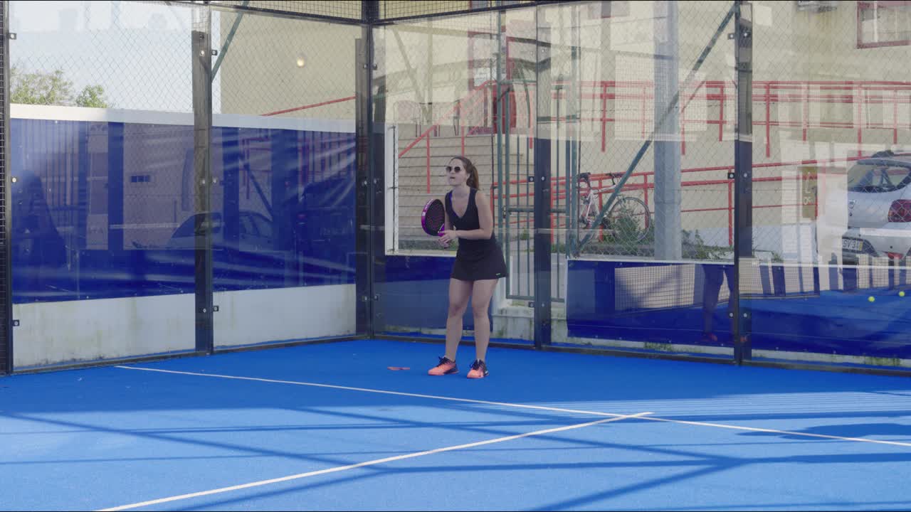 Giovane atleta concentrato sull'allenamento di paddle, migliorando la tecnica su un campo blu