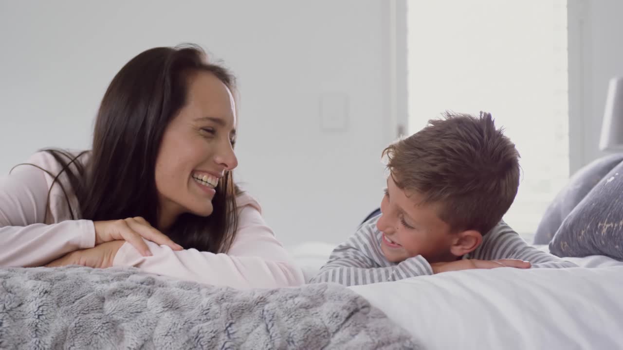 Madre e hijo acostados juntos en la cama en casa 4k | Vídeo de stock ...