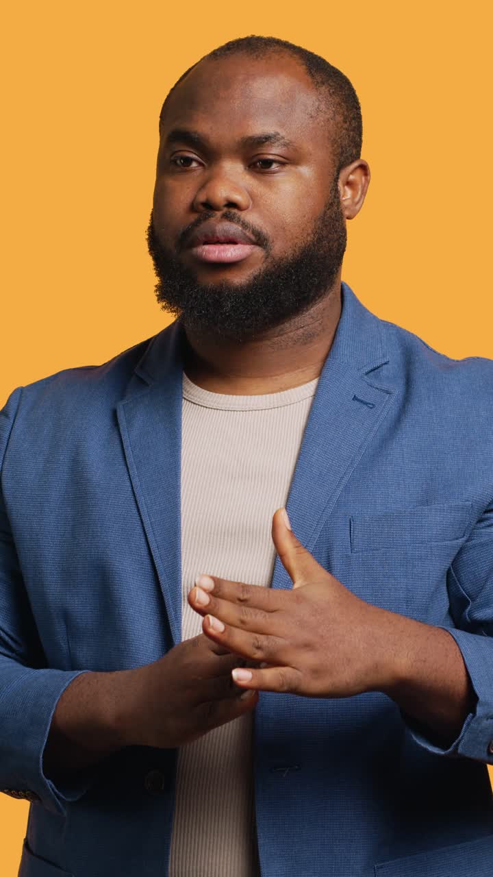 Vertical video Portrait of assertive man asking for timeout, studio background