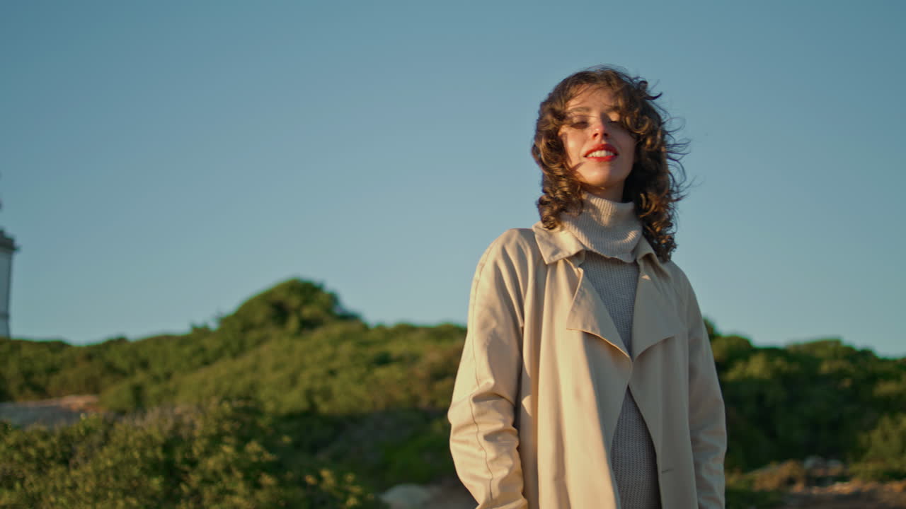 미소 짓는 여자 해변 저녁 등대. 무관심 한 소녀 포즈