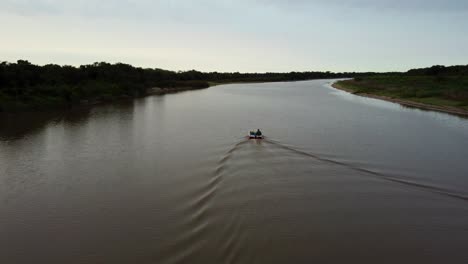 stunning overtake shot of fisherman sailing in calm water, tebicuary river, paraguay