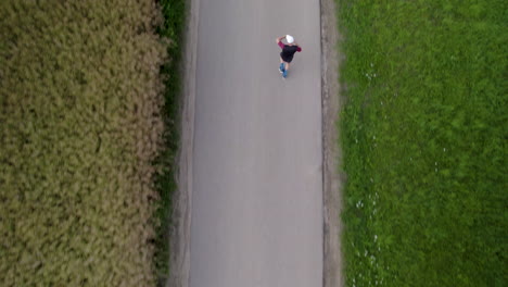 top down aerial - a runner is training on a narrow asphalt road