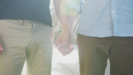 close up of loving male gay couple holding hands outside on street