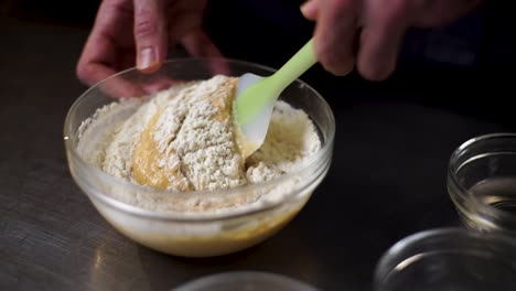 cook prepares pudding by mixing ingredients in a glass bowl