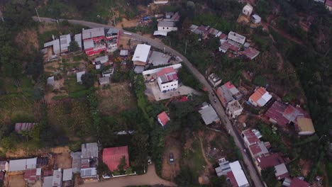 Vista-Aérea-De-Motociclistas-Atravesando-La-Ciudad-De-Estaño-En-Las-Montañas-Costeras-De-Guatemala