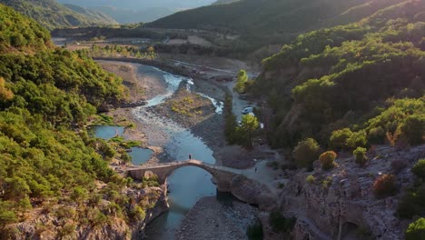 aufnahme von sonnenuntergang der brücke über den fluss im langarica-canyon in albanien