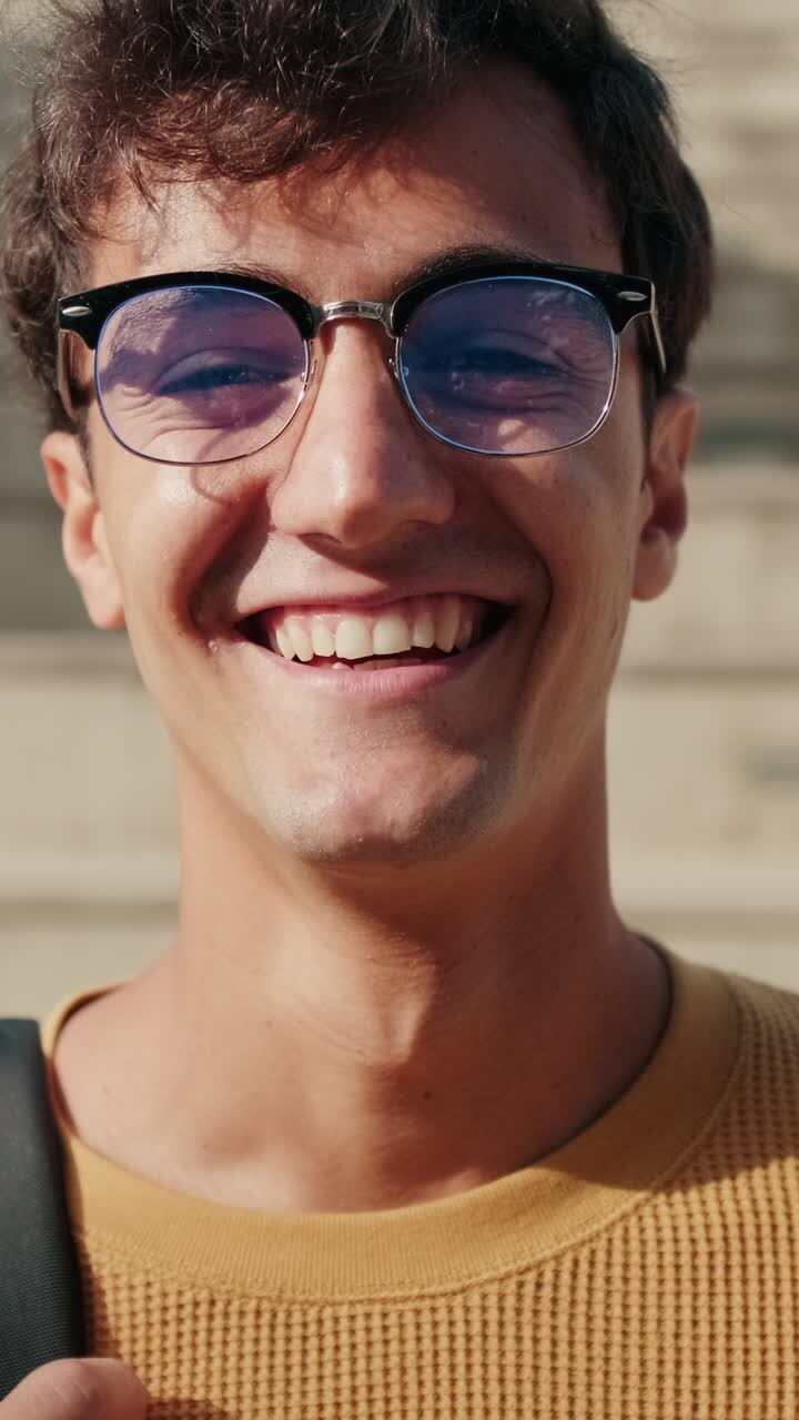Portrait of cheerful European boy with glasses, male student with his friends in