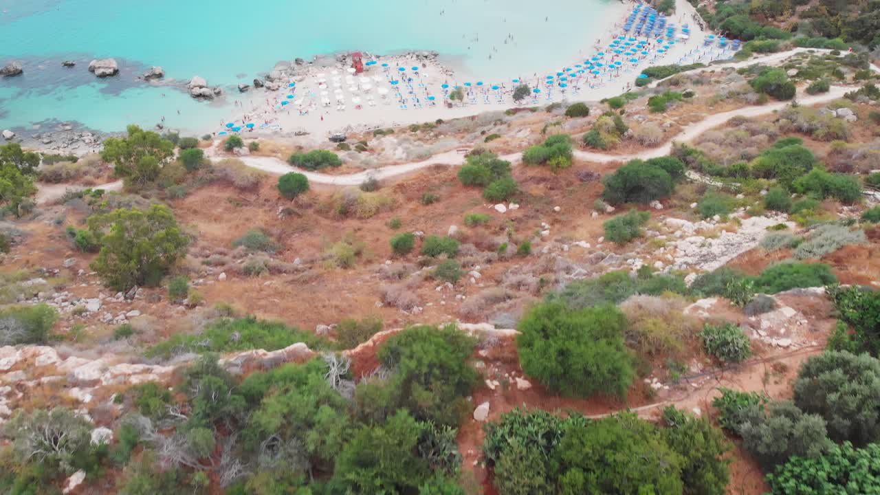 Cinematic drone shot of Konnos Beach at daylight. People swimming and having fun