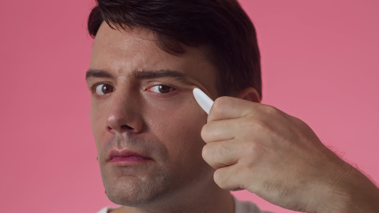 Gen Y Man Practicing Massage with Gua Sha Tool on Face