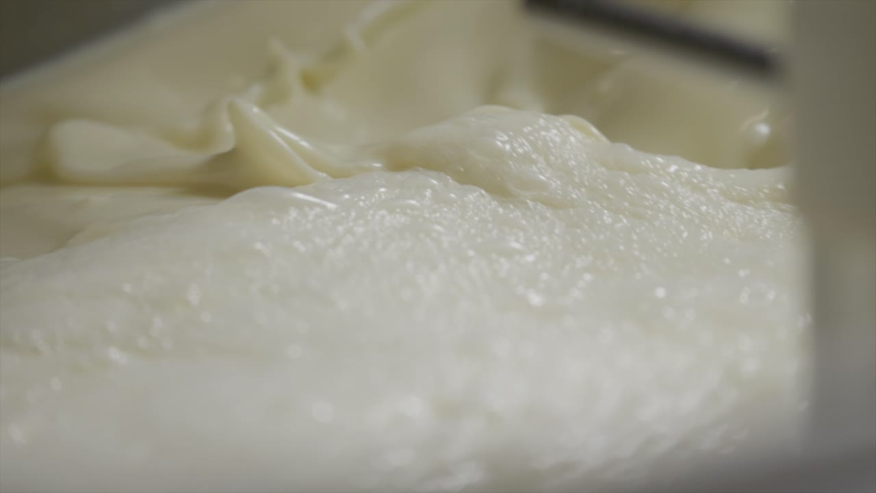 disparo macro lento de leche líquida blanca salpicando dentro de la máquina
