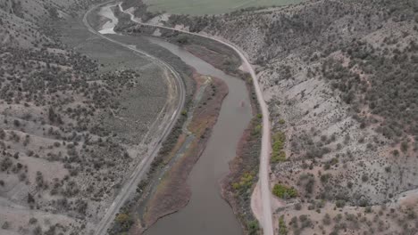 sedán conduciendo a lo largo del río colorado en una carretera remota