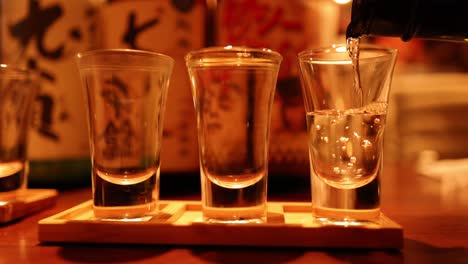 sequence of sake being poured into glasses