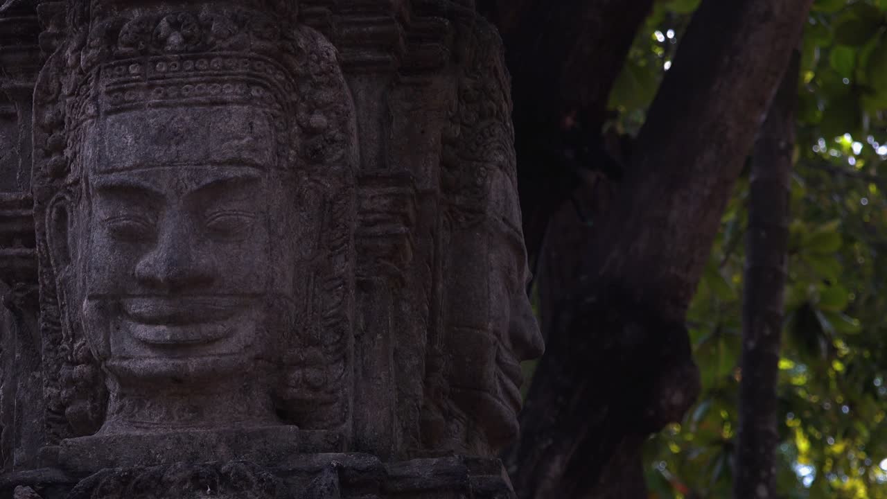 Immagine per slider: statua in pietra Khmer con alberi sullo sfondo