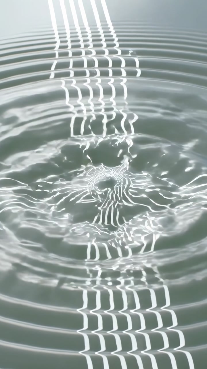 Vertical video: Showing water rings warping bright parallel lines after droplet striking tank