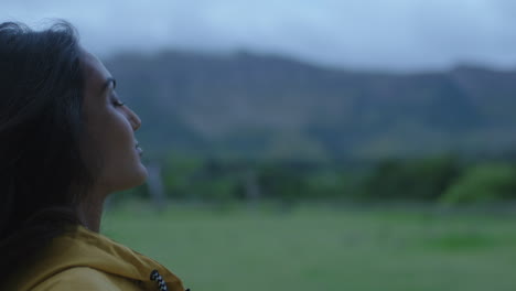 una joven india mirando hacia arriba respirando con los ojos cerrados disfrutando de un estilo de vida exitoso en una aventura de viaje sola en un tranquilo campo