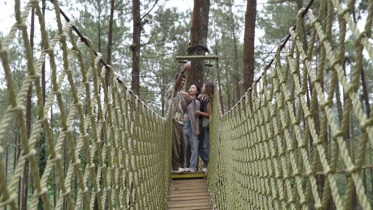 Asian Friends Taking Selfie on Forest Rope Bridge in Indonesia